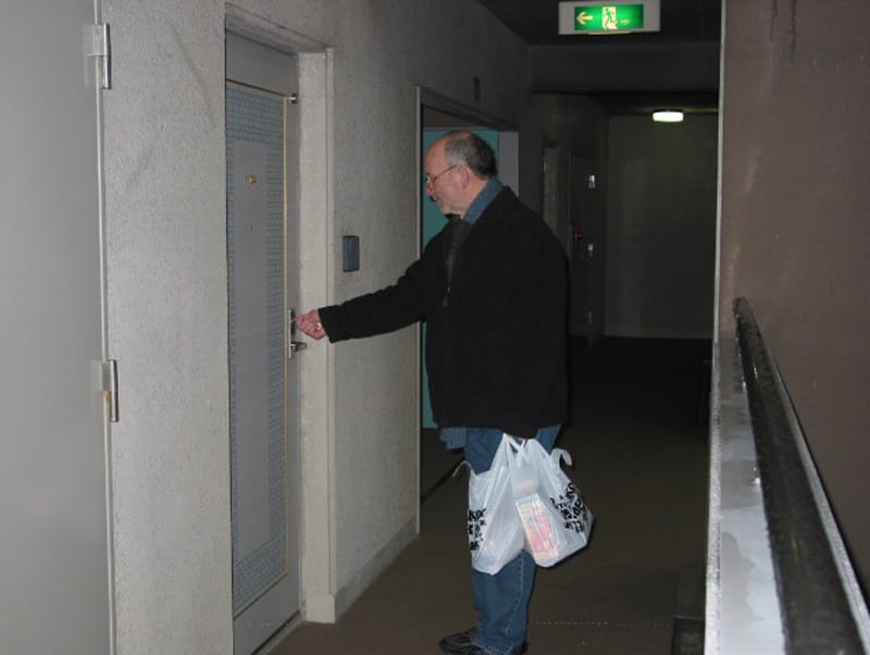 Michael Busha opening his apartment door, carrying his bags after training