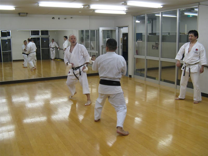 Karateka sparring on the wooden floor of the Kobe dojo